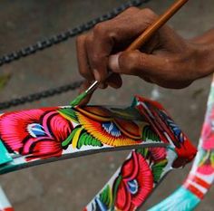 a person is holding scissors in their hand while they are painting the fabric on a bicycle