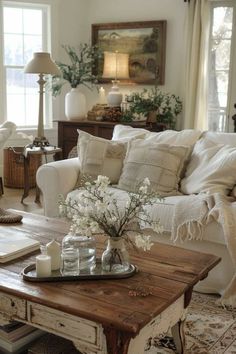 a living room filled with lots of furniture and flowers on top of a coffee table