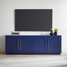 a blue entertainment center with a flat screen tv mounted on it's sideboard