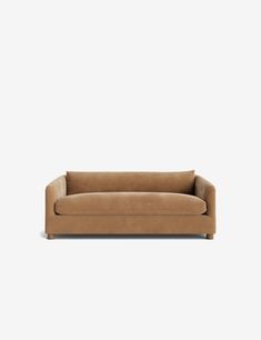 a brown couch sitting on top of a white wall