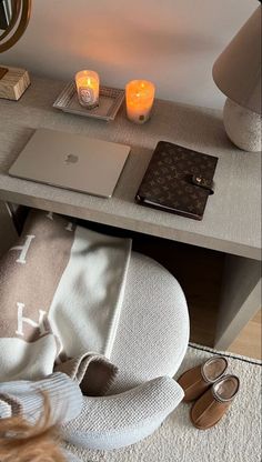 a laptop computer sitting on top of a wooden desk next to a lamp and other items