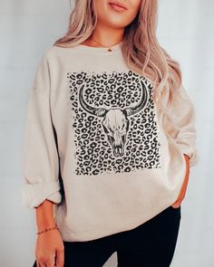 This stylish and unique Texas-inspired longhorn skull leopard print cowgirl sweatshirt will have you looking fashionable and ready for a rodeo in the desert. The boho western crewneck cow skull hoodie is perfect for any cowgirl who loves a good rodeo. ⭐️ * I T E M * I N F O* ✦ Gildan Unisex Sweatshirt ✦ This is made from a cozy, thinner material- perfect year round!  ✦ Printed using Direct To Garment style- Inks are printed directly into the fabric. ✦ Different sizing may effect placement of fin Casual Long Sleeve Tops With Cow Print, Casual Cow Print Tops For Fall, Casual Long Sleeve Cow Print Top, Western Crewneck, Austin Bachelorette, Leopard Print Sweatshirt, Longhorn Skull, Leopard Outfits, Diy Shirts