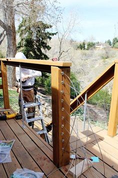 a man on a ladder working on a wooden structure