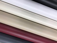 many different colored fabrics are stacked together