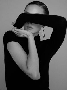 a black and white photo of a woman covering her face