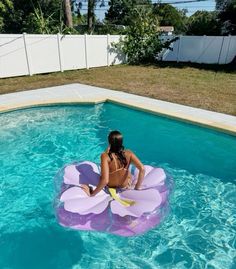 a woman sitting on an inflatable raft floating in a pool