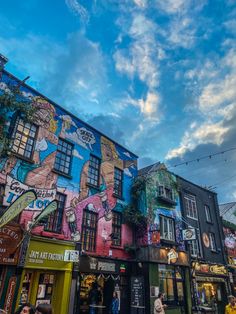 people are walking around in front of some colorful buildings