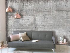 a grey couch sitting in front of a window