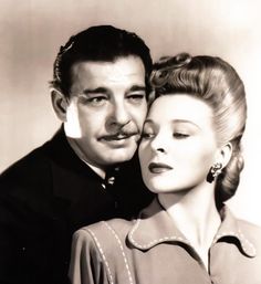 an old black and white photo of a man with a mustache hugging a woman's head