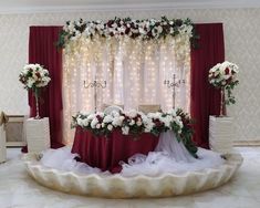 a wedding setup with flowers and lights on the wall behind the ceremony table is ready for guests to arrive