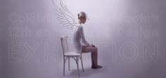 a woman sitting on top of a chair next to a white wall with angel wings