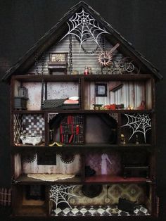 a doll house with lots of furniture and decorations on the front porch, including a spider web