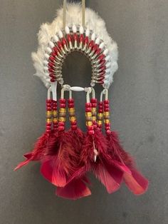 a red and white headdress with feathers hanging from it's back end