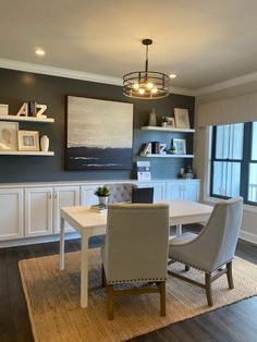 a dining room table and chairs in front of a large window with bookshelves