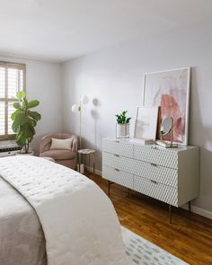 a bedroom with white walls and wooden floors