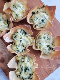 small shells filled with spinach and cheese on a cutting board