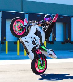 a person on a motorbike doing a trick in the air with one hand