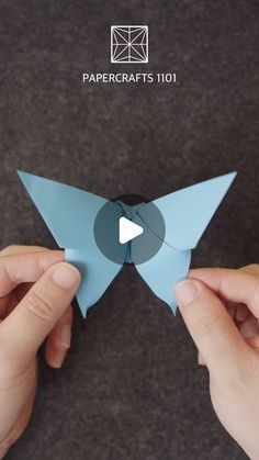 two hands are holding an origami bird