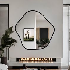 a living room with a fire place and large mirror on the wall above it's fireplace