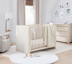 a baby crib in a white nursery room