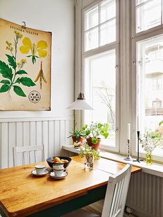 a wooden table sitting in front of two windows