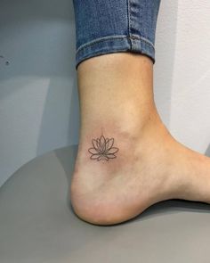 a woman's foot with a lotus tattoo on it