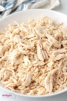 shredded chicken in a white bowl on a table