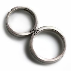 two silver rings with black crosses on them