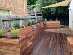 a wooden deck with planters and benches