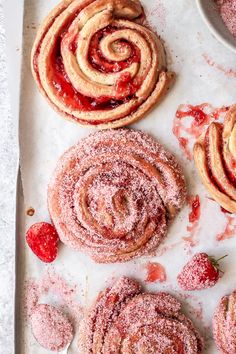 powdered sugar rolls and strawberries on a baking sheet