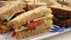 there are several sandwiches on the plate with toothpicks stuck in them and one is cut in half