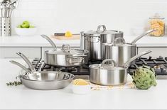 stainless steel pots and pans sitting on a kitchen counter