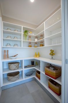 a white pantry filled with lots of shelves and baskets