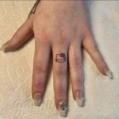 a person's hand with a hello kitty tattoo on it