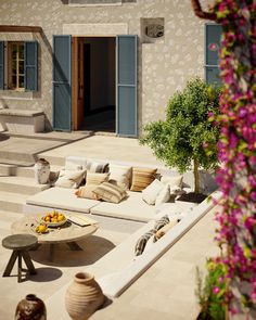 an outdoor living area with couches, table and potted plant