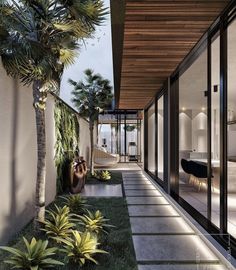 an outdoor area with grass and plants next to a house that has sliding glass doors on both sides