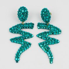 This is part of Chairish’s Costume Jewelry assortment.  Richard Kerr designed these elegant pierced earrings in the 1980s. They are made up of his signature paved crystal rhinestones. They feature a long dangle zig-zag turquoise resin shape, all covered with turquoise color crystal rhinestones. There is no visible signature, but the design is a designer's signature. The earrings are for pierced ears. Richard Kerr began designing jewelry in Dallas, TX, in 1980. Measurements: 1.25 in wide (3.2 cm) Turquoise Earrings For Evening, Turquoise Drop Crystal Earrings For Party, Designing Jewelry, Turquoise Resin, The 1980s, Pierced Earrings, Turquoise Color, Color Crystal, Pierced Ears