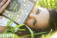 a woman laying in the grass reading a book