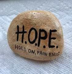 a rock that says hope hold on, pain ends