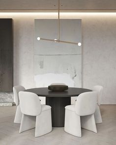 a round table with four white chairs around it and a mirror on the wall behind it