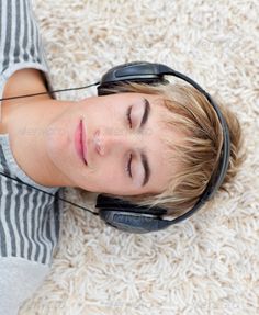 a young boy wearing headphones laying on the floor - stock photo - photoshop