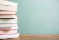 a stack of books sitting on top of a wooden table