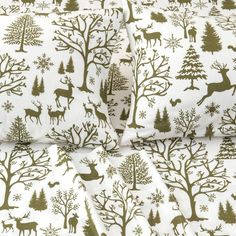 a white sheet with green trees and deers on it