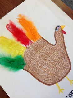 a paper plate with a turkey and feathers on it