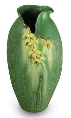 a green vase with yellow flowers on the inside of it's body and bottom