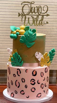 a three tiered cake with green and gold decorations