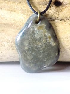 This pendant is made with a coastal stone, either ocean or river. The stone is not tumbled or shaped but is in its natural form, except for the drilled hole. Therefore, the stone/rock will have its natural "imperfections" just as nature made it. This adds character and uniqueness to the piece. They make a perfect gift for rockhounds, yoga\ Zen lovers, surfers or just anyone who loves the beauty of nature. This pendant is gray with unique markings on the front.  Then the entire piece is coated with a high gloss shellac to give it a nice sheen and protect the design. Pendant has a metal split ring and hangs on an adjustable wax cotton cord with pull apart clasp.  To adjust the length of the cord: 1. pull  open the clasp; 2. push knot through clasp end on both sides; 3. tie a new knot at the Rock Pendant, Boho Hippie Style, Natural Form, Casual Jewelry, Natural Rock, Pull Apart, Rock Hounding, Jewelry Boho, Natural Forms