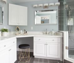 a bathroom with white cabinets and gray flooring