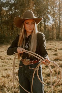 a woman wearing a cowboy hat and holding a lasso