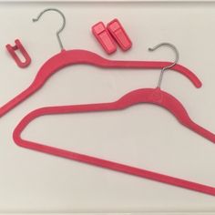 two pairs of pink plastic clothes hangers with clips on white background, next to each other